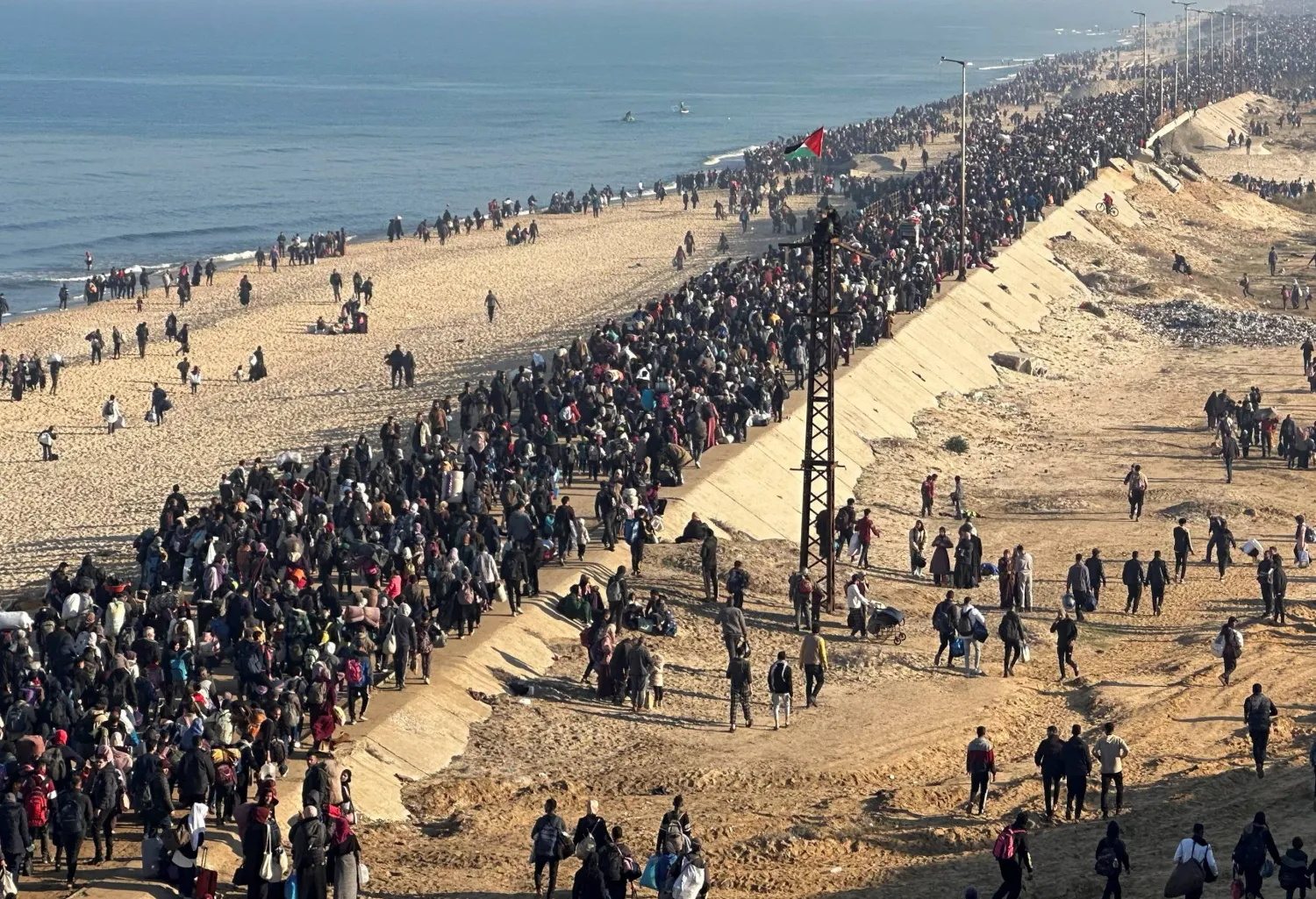 توجّه آلاف الفلسطينيين الذين جرَّ بعضهم عربات محمّلة بالأمتعة باتجاه حاجز نتساريم على شارع الرشيد الممتد على طول ساحل غزة (رويترز)