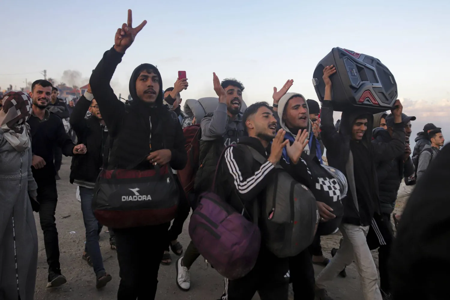 رغم مشقة الطريق فلسطينيون يحتفلون خلال سيرهم إلى منازلهم فى شمال القطاع (أ.ب)