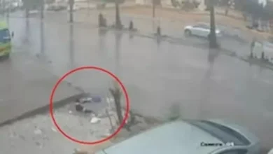 صورة حفرة مغطاة بمياه الأمطارعميقة تبتلع فتاة أمام المارة